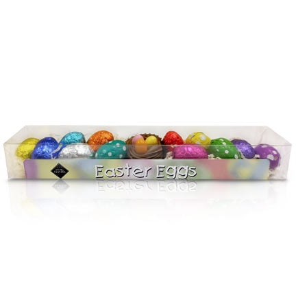 A vanilla gianduja nest with three eggs filled with fruit jelly surrounded by brightly colored foil-wrapped chocolate eggs, 63% dark & 39% milk, filled with ganache, pralinΓ©, & gianduja, a smooth and creamy mix of dark chocolate and pure hazelnut paste.